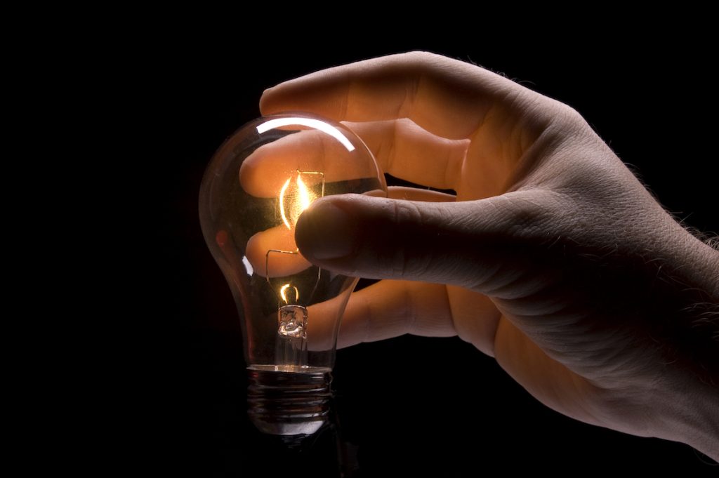 An image of a hand holding a lightbulb.